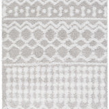 Close-up of the Vernonburg Shag Area Rug. Light gray and white shag rug with geometric diamond and zig-zag pattern. Soft texture. Design-Rectangle-5373