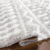 Close up of the light gray Vernonburg Shag Area Rug showing its soft texture and subtle geometric pattern. Fold